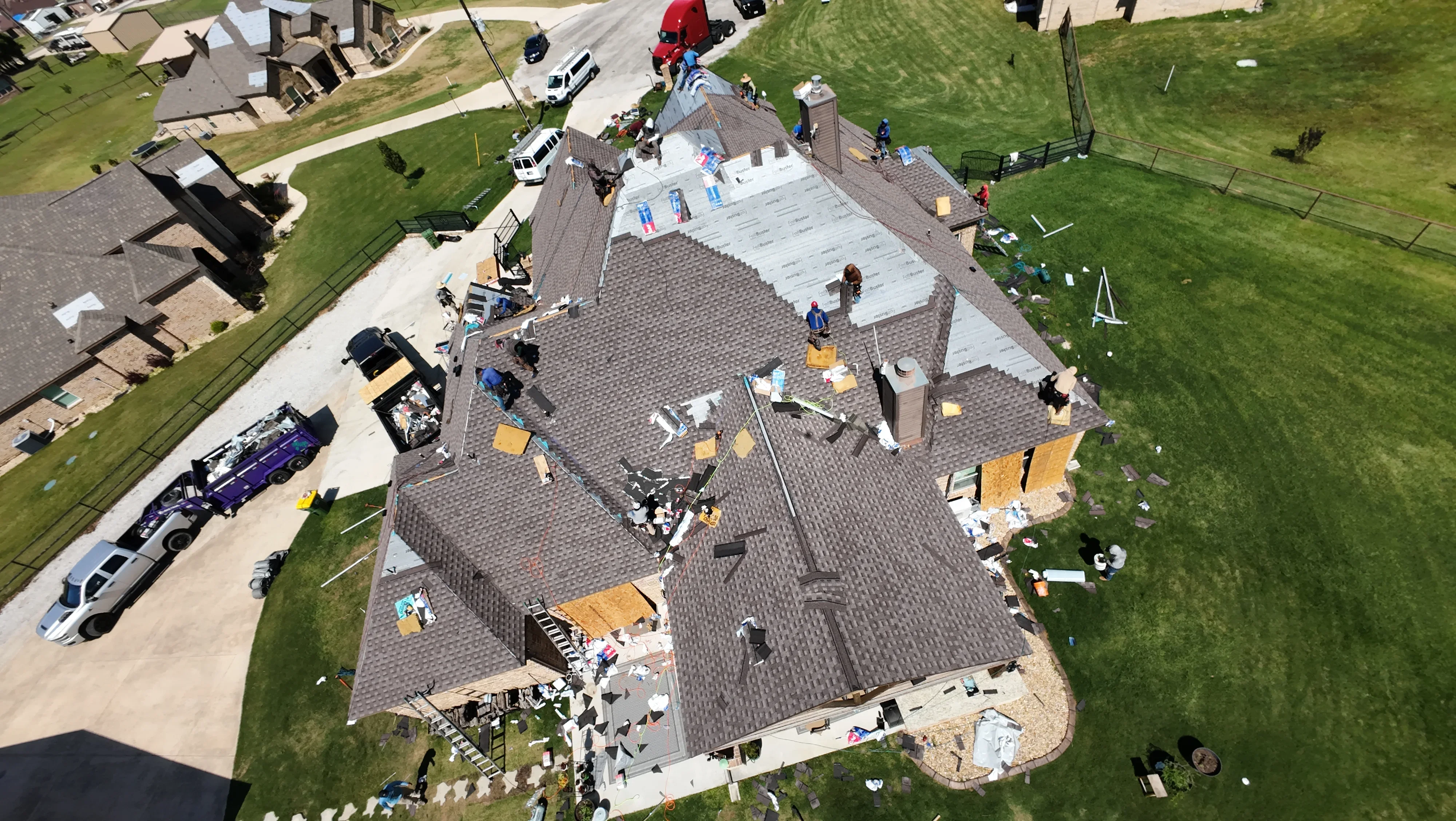 Aerial view of residential roof replacement with new architectural shingles and protective underlayment installed