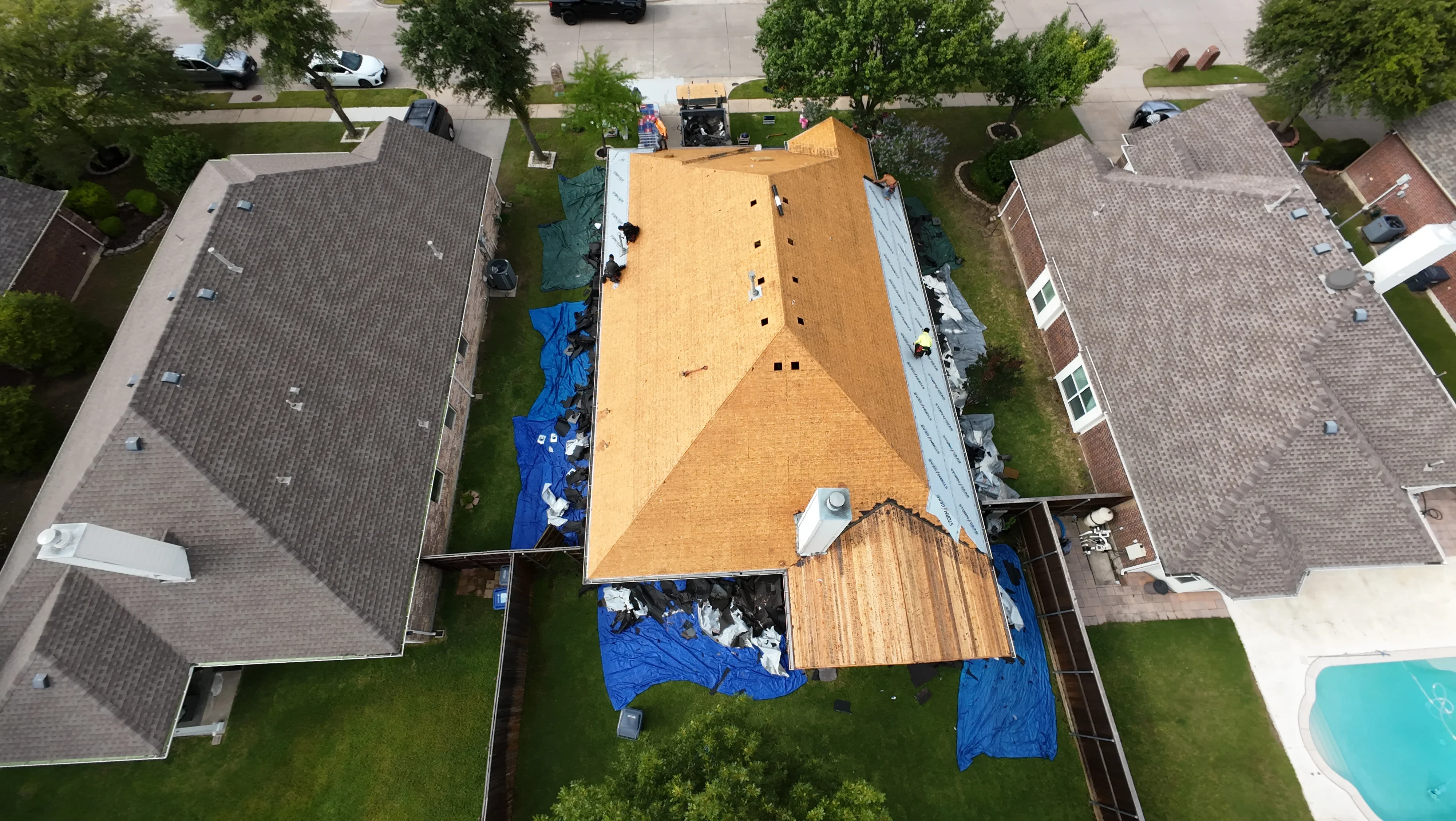 Aerial view of roof replacement with plywood sheathing and underlayment installation